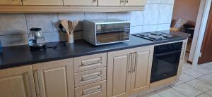a kitchen counter with a microwave and a stove at 9 on Deimos Ave in Polokwane +10 photos