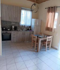 a kitchen with a table and chairs and a refrigerator at Tonia's guest house in Sami