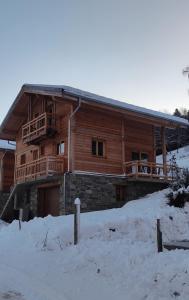 a log cabin with snow in front of it at Chalet recent , 5 min télésiège de la Roche, virage 12 in La Plagne Tarentaise