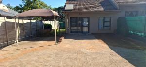 a house with an umbrella in front of a driveway at 9 on Deimos Ave in Polokwane