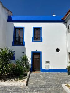 a white house with blue trim and a door at Alqueva - Casa Da Luz in Mourão