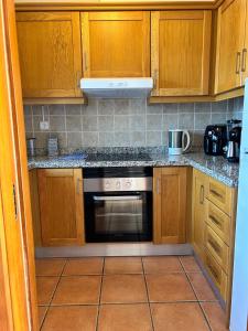 a kitchen with wooden cabinets and a stove top oven at Alqueva - Casa Da Luz in Mourão