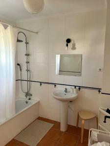 a bathroom with a sink and a bath tub and a mirror at Alqueva - Casa Da Luz in Mourão