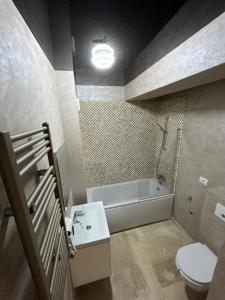 een badkamer met een bad, een toilet en een wastafel bij SIGMA suites in Constanţa +15 foto's