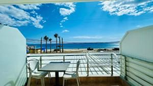 a balcony with a table and chairs and the beach at VANGJELIS HOTEL in Himare