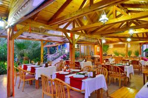 un restaurant avec des tables et des chaises blanches et des plafonds en bois dans l'établissement Margaritaotel, à Kumluca