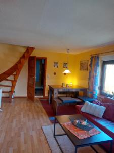 a living room with a couch and a table at Ferienhaus am Vogelsberg in Hämmern