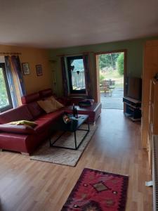a living room with a red couch and a table at Ferienhaus am Vogelsberg in Hämmern