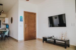 a living room with a wooden door and a table at Amazing Oceanviews Condo In The Heart Of Las Terrenas in Las Terrenas