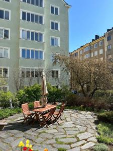 a table and chairs with an umbrella in front of a building at Peaceful Studio in Töölö in Helsinki