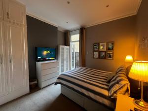 a bedroom with a bed and a flat screen tv at Wimbledon fortnight in London