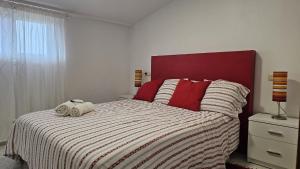 a bedroom with a bed with two towels on it at Area Pequena ATICO in Malpica +7 photos