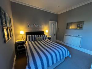 a bedroom with a bed with blue and white stripes at Wimbledon fortnight in London