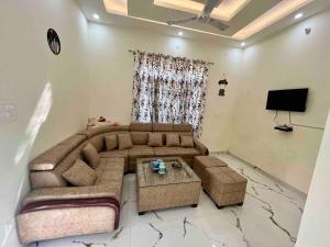 a living room with a couch and a tv at Sukoon Guaranteed in Jhājra