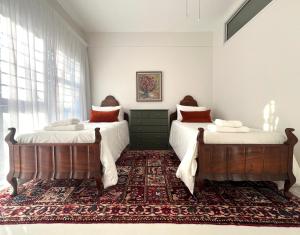 two beds in a bedroom with a rug at Bosch & Bloom in Stellenbosch