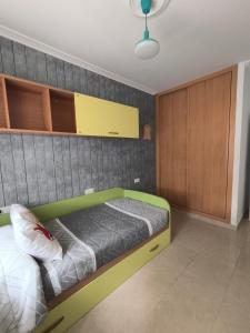 a bedroom with a green bed and wooden cabinets at Casa O Con in O Grove +14 photos