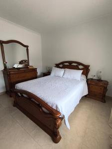 a bedroom with a wooden bed and two night stands at Casa O Con in O Grove