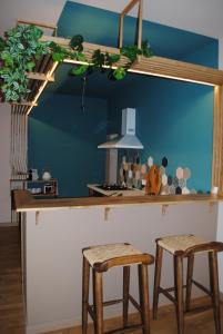 une cuisine avec un comptoir et deux tabourets dans l'établissement L'Echiquier, à Castres 18 autres photos