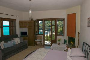 a living room with a couch and a table at The Bird's Sea View in Agios Ioannis Pelio