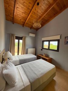 2 camas en un dormitorio con techos y ventanas de madera en Villa Fanouris, en La Canea 48 fotos más