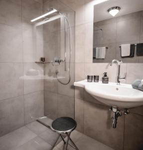 une salle de bain avec lavabo et douche dans l'établissement Haus Alpin, à Ellmau 41 autres photos