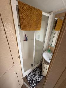 a small bathroom with a shower and a sink at Nockys nook in Filey +27 photos