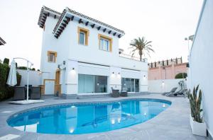 eine Villa mit einem Swimmingpool vor einem Haus in der Unterkunft Villa Fresno with Private Pool on gated 5* Mar Menor Golf Resort - 3 Bed/3 shower/WC in Torre-Pacheco