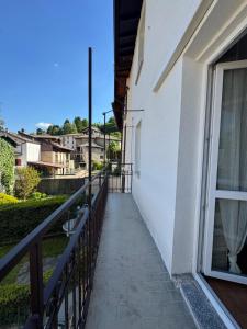 ein Balkon eines weißen Gebäudes mit einem Fenster in der Unterkunft Sormano Apartments - THE V Collection in Sormano
