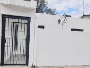 un edificio bianco con un cancello sul lato di Mate host 2 a Córdoba