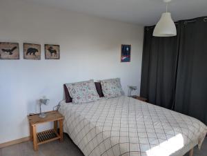 a bedroom with a bed with a white comforter at Entre lac et pistes in Gérardmer