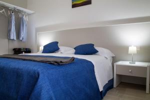 1 dormitorio con 1 cama con sábanas azules y blancas en B&B Da Vinci, en Matera