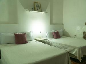 two beds sitting next to each other in a room at La Casa de Mamapán Hotel Colonial Ahuachapan in Ahuachapán