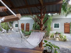 eine Hängematte auf einer Terrasse mit einem Gebäude in der Unterkunft Le Pes Villas in Khanom