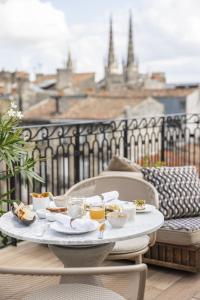 a tray of food on a table on a balcony at Hôtel Singulier Bordeaux - Boutique Hôtel & Spa Anne Semonin in Bordeaux