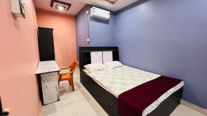 Un pequeño dormitorio con una cama y una silla. en The Aurelia Inn, en Sibsāgar 3 fotos más