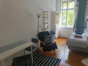 a room with a desk and chairs and a bed at Nusi Apartman in Budapest