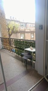 a table and chair on a balcony with a building at Nusi Apartman in Budapest