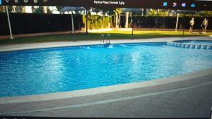 una piscina con acqua blu in un parco di Ático Primera línea de playa Playa Dorada a El Borseral