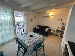 a living room with a table and a couch at Isola Rossa House in Isola Rossa +16 photos