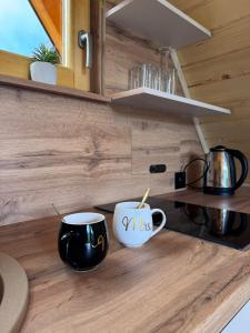 zwei Kaffeetassen auf einer Theke in einer Küche in der Unterkunft Cottage Lana 2 in Jajce