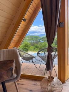 Zimmer mit einem großen Fenster mit einem Stuhl und einem Tisch in der Unterkunft Cottage Lana 2 in Jajce
