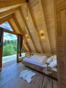 ein Bett in einem Zimmer mit Holzdecke in der Unterkunft Cottage Lana 2 in Jajce + 36 Fotos
