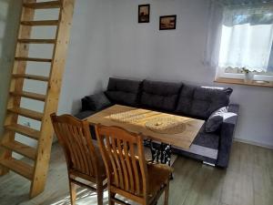 a living room with a table and a couch at Urocze Roztocze Jacnia - domek 1 in Jacnia +26 photos