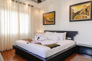 a bedroom with a large white bed with white curtains at Khách sạn Le Domaine De Cocodo in Hue +47 photos