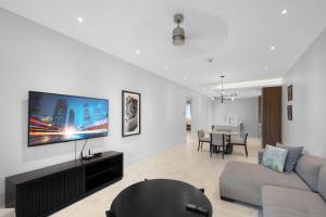 a living room with a couch and a tv on a wall at Modern Condo at One Cable Beach with Balcony in Nassau