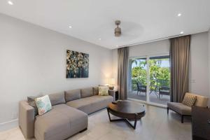 a living room with a couch and a table at Modern Condo at One Cable Beach with Balcony in Nassau