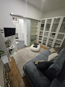 a living room with a blue couch and a television at La Petite Blanche in Cologne +5 photos