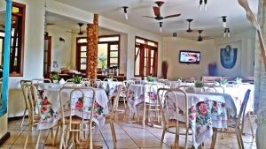 イーリャ・グランデにあるPousada Só Naturezaのテーブルと椅子(白いテーブルクロス付)が備わる客室です。