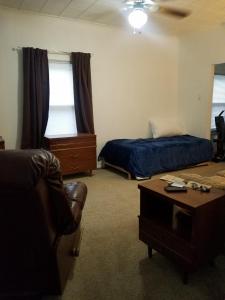 een kamer met 2 bedden, een stoel en een tafel bij Roomy 1 Bdrm House-Hi-Speed Internet-Great for Cple-Sml Family-Easy to Get About in Whitehall