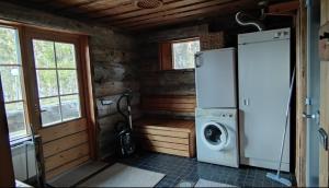 a kitchen with a refrigerator and a washing machine at Kelokantola by the lake in Ruka